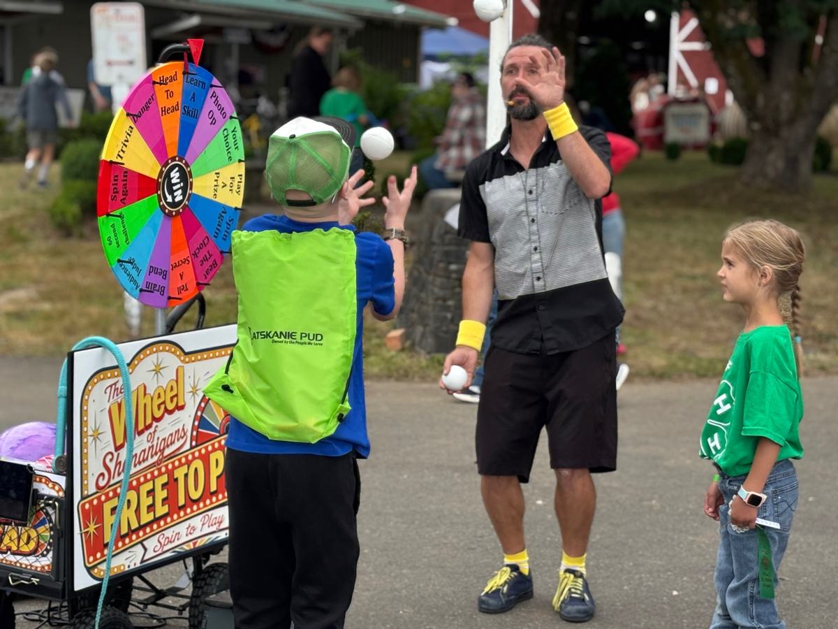 Matt Baker teaching a boy to juggle beside the wheel
